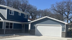 A two-story house with a garage, a covered entryway, and a driveway.