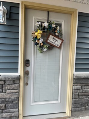 A front door with a welcome sign, a keyhole, and a keypad lock. - Lake view house with private pier lake access (Knox)