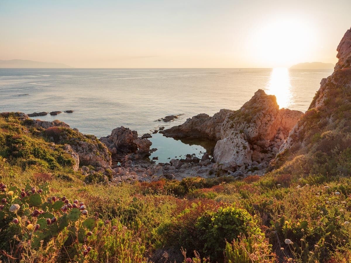 A coastal landscape with rocky terrain and vegetation.