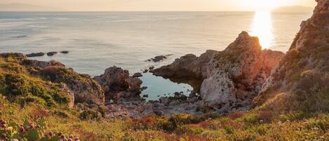 A coastal landscape with rocky terrain and vegetation.