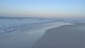 Une plage aux vagues douces et sous un ciel dégagé.