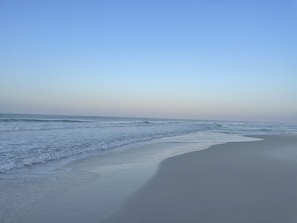 Enjoy a serene beach experience with gentle waves lapping onto the shore.