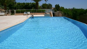 Una piscina con acqua cristallina, un trampolino e una postazione per il bagnino.