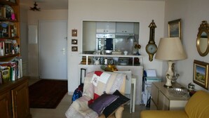 Un ambiente compatto con angolo cottura, zona pranzo e libreria.