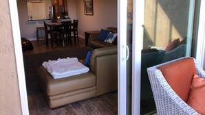A living room with a sofa, a chair, and a dining area with a table and chairs.