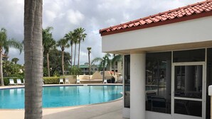 A pool area with lounge chairs and palm trees.