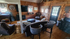 A cozy cabin interior with a wooden interior, a fireplace, a television, and a dining area. - COZY CABIN AT PATOKA LAKE(in happy hollow) (Birdseye)