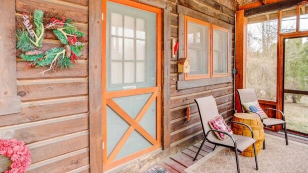 A log cabin with a porch, wooden doors, and a view of the outdoors. - COZY CABIN AT PATOKA LAKE(in happy hollow) (Birdseye)