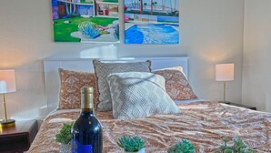 A neatly made bed with a patterned bedspread, a bottle of wine, and glasses on a tray. - Posh Villa Sleeps 12 w/ 4 bedroom, 3 bath Pool & Spa (Indio)