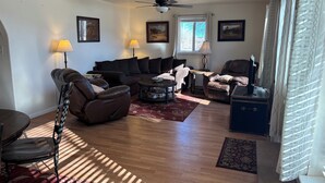 A living room with a sofa, armchairs, a coffee table, and a ceiling fan. - #6 Home in the Heart of Utah (Torrey)