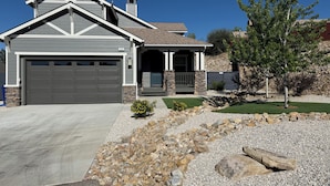 A residential house with a garage, stone foundation, and a landscaped front yard with a tree and a small bush. - Checkout our weekday discount! w/Central AC. (Big Bear)