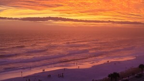 A beach with people walking and standing, and a sunset in the background. - Coastal Bliss and Million Dollar Views (Miramar Beach)