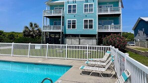 A two-story building with a swimming pool, white railings, and a flag. - Blue Water; Oceanview condo, Atlantic Beach (Atlantic Beach)