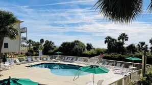 Ein Poolbereich mit mehreren Pools, Liegestühlen und Sonnenschirmen.