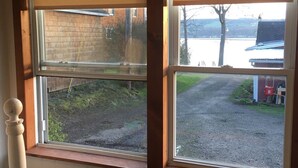 Ein Zimmer mit Fenster, das auf einen Kiesweg und ein Gebäude Blick gewährt.
