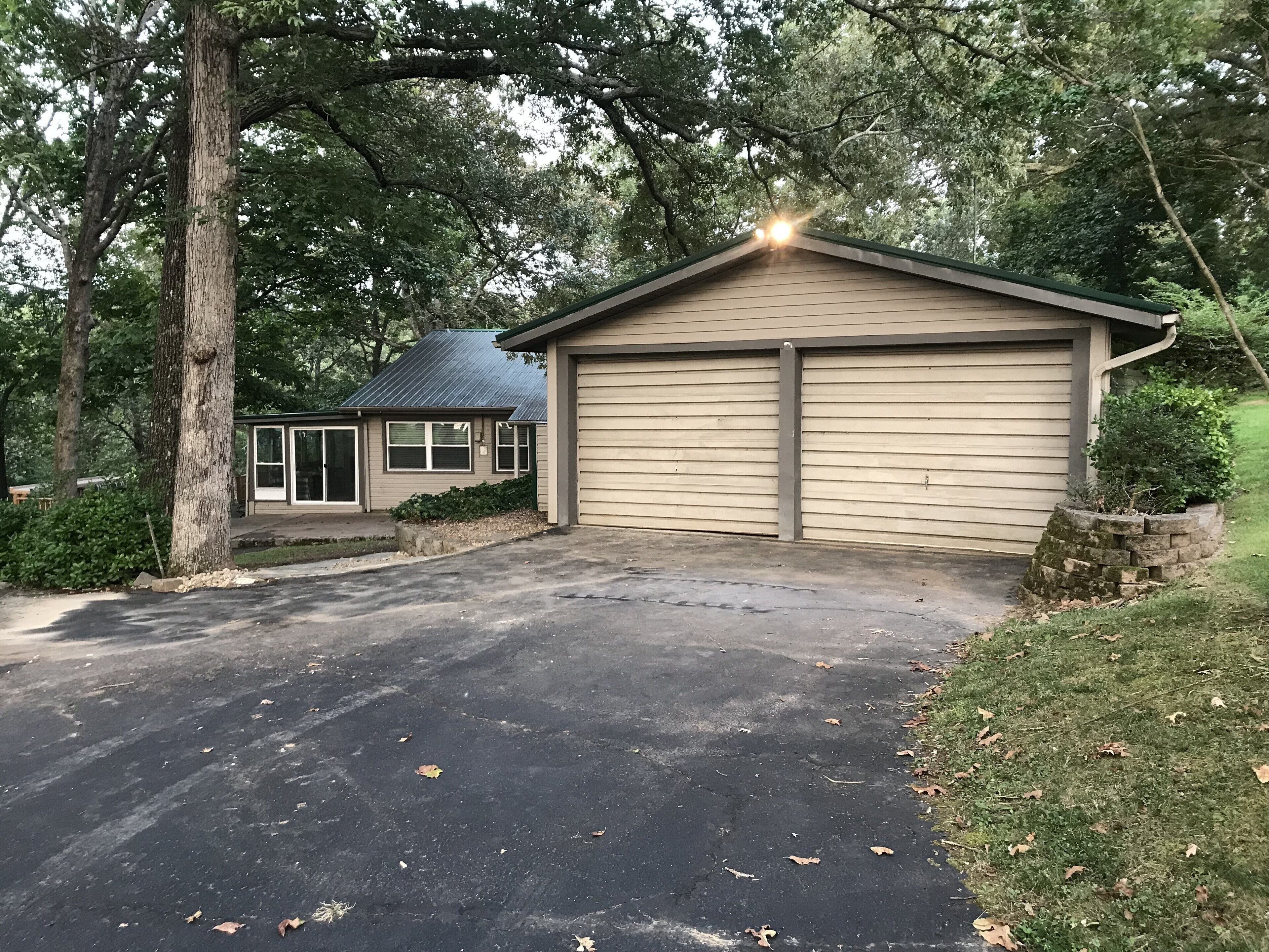 A single-story house with a garage, a covered patio, and a driveway.