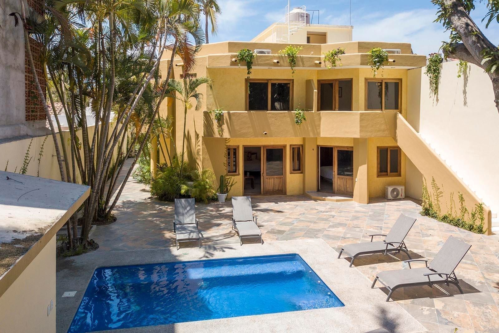 Alberca al aire libre, sombrillas en la alberca y camastros 