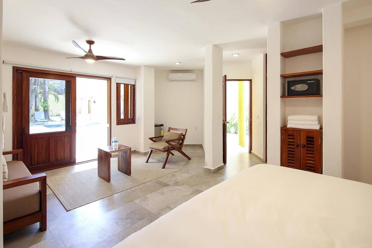 A bedroom with a bed, a desk, a chair, and a wardrobe.