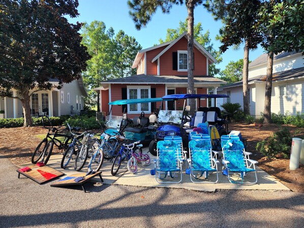 A residential area with a red house, bicycles, and a golf cart.