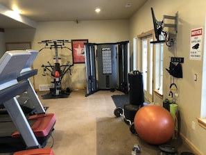 A gym with treadmills, weight machines, a punching bag, and a large exercise ball. - Powder Mountain Family Friendly Condo @ Moose Hollow Sleeps 6! (Eden)