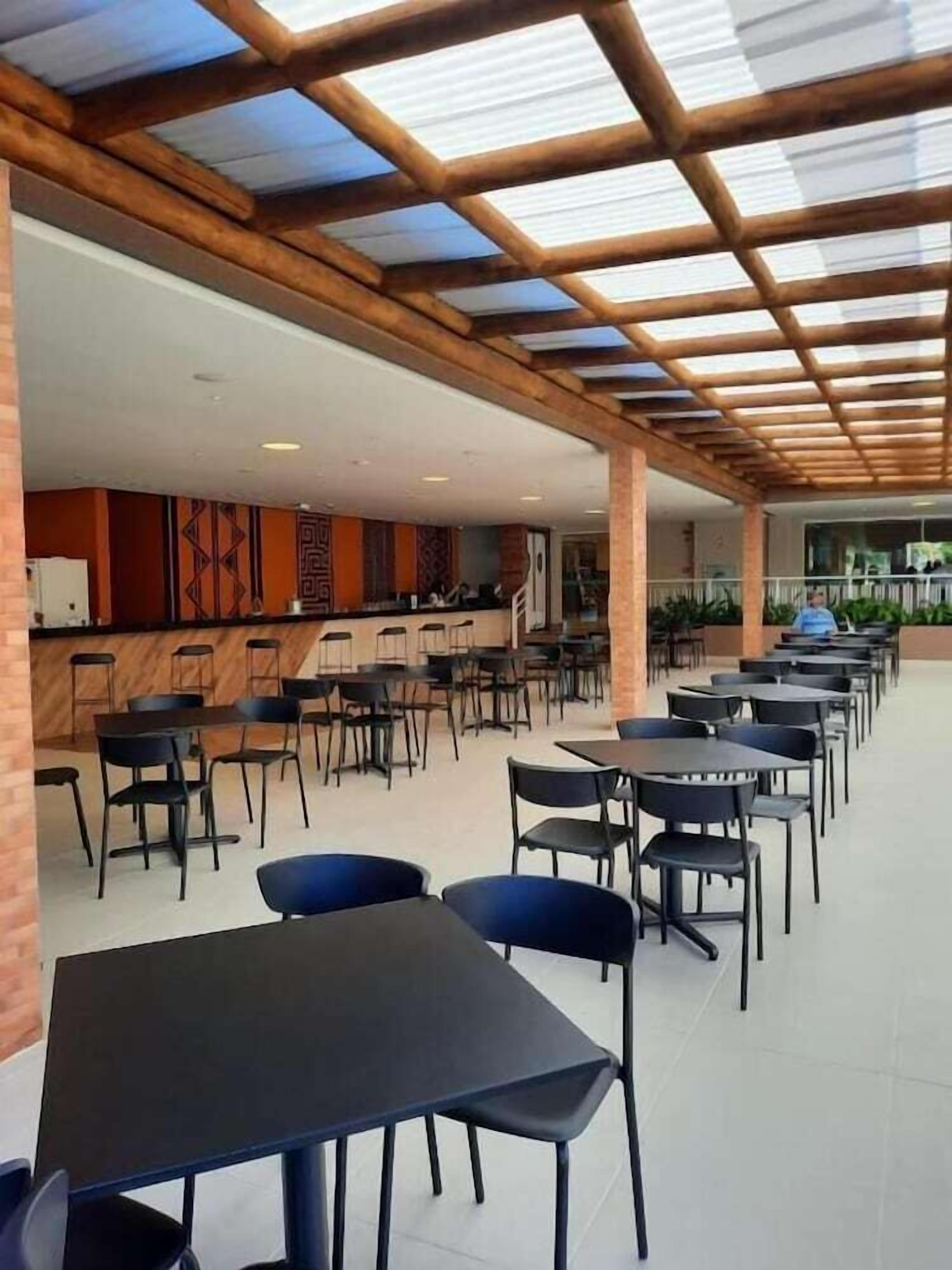 A spacious indoor area with multiple tables and chairs arranged for dining.