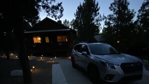 Un camino de entrada que lleva a una casa con un coche estacionado adelante.