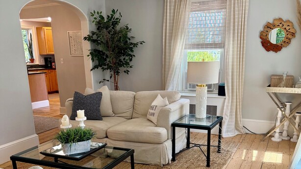 A living room with a sofa, coffee table, and a view of the kitchen.