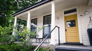 A house with a yellow door and the number 311 on the front.