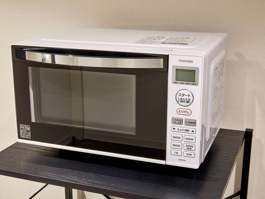 Un horno microondas Toshiba sobre un soporte metálico negro.