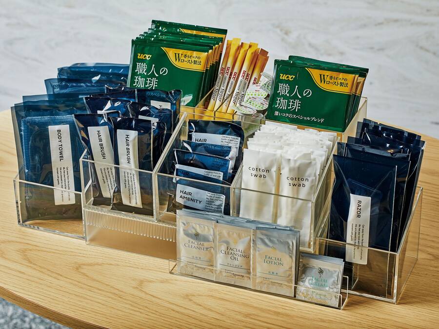 A display of various personal care products including body towels, hair brushes, cotton swabs, razors, facial cleansing oil, and facial lotion.
