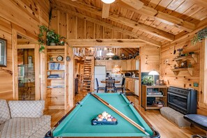 Relax in a warm, inviting space with a pool table and comfortable seating area, plus a kitchen with dining table.
