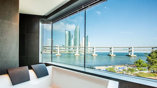 A modern room with a large window overlooking a cityscape and a bridge. - AG405 Hotel (Busan)