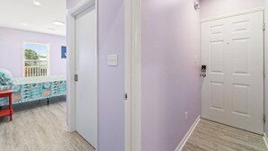 Una habitación con cama, ventana y puerta.