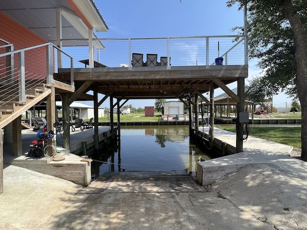 Uma área de cais coberta com um deck de madeira, um calçadão de concreto e uma pequena massa de água.