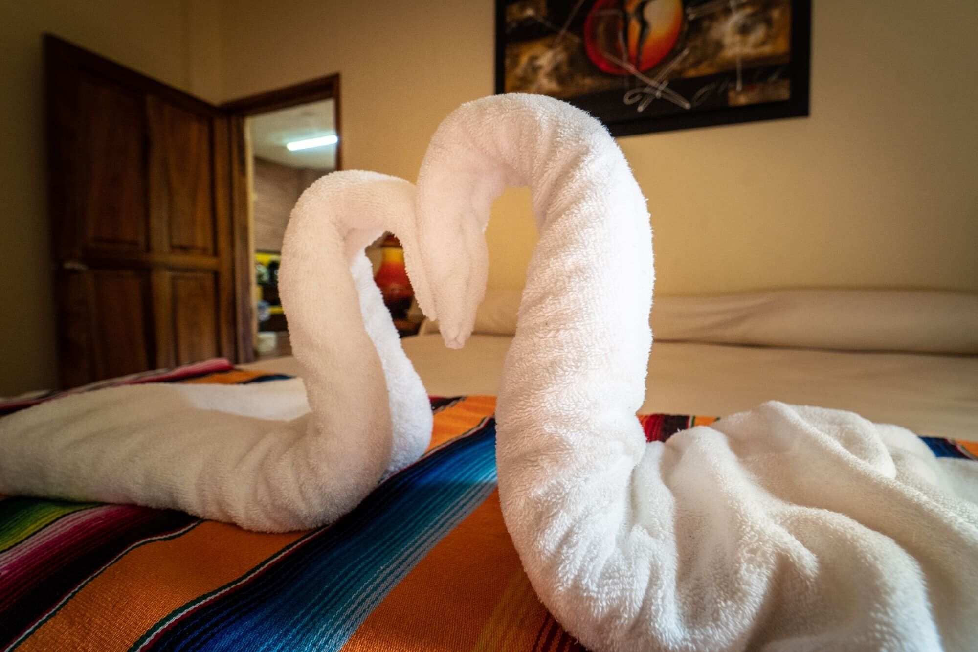 Ein Bett mit einem weißen Handtuch, geformt wie ein Schwan.
