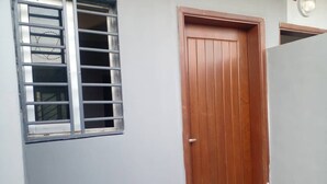 A closed wooden door with a metal window grille. - Lovely 1-Bed duplex house (BINGERVILLE)