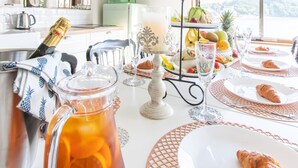 A breakfast setting with a pitcher of orange juice, a croissant, and a fruit display. - West coast villa Shirahama (Shirahama)