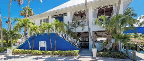 A building with a sign reading "Kaibo Yacht Club" and a staircase leading to the entrance.
