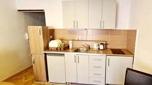 Een kleine keuken met een spoelbak, een koffiezetapparaat en een afwasschaal.