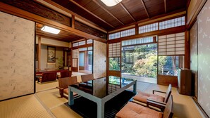 Ein traditioneller japanischer Raum mit Tatami-Böden, einem niedrigen Tisch und Shoji-Schiebetüren.