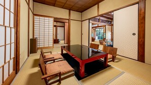 Ein traditioneller japanischer Raum mit Tatami-Boden, einem niedrigen Tisch und Schiebetüren.