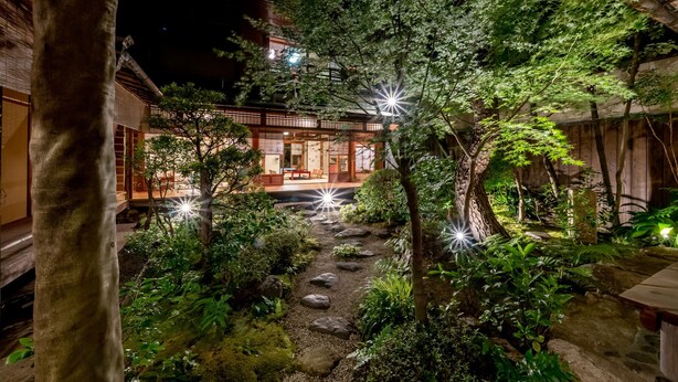 Ein traditionelles japanisches Gebäude mit einem Gartenweg, der zum Eingang führt.
