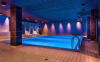 Una piscina techada, sillones reclinables de piscina