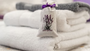 A stack of neatly folded towels with a small embroidered tag on one. - Lavender Room (Dubrovnik)
