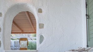 Ein Schlafzimmer mit Steinwand, einem Fenster mit Holzbank und einem Bett mit gestreifter Bettwäsche.