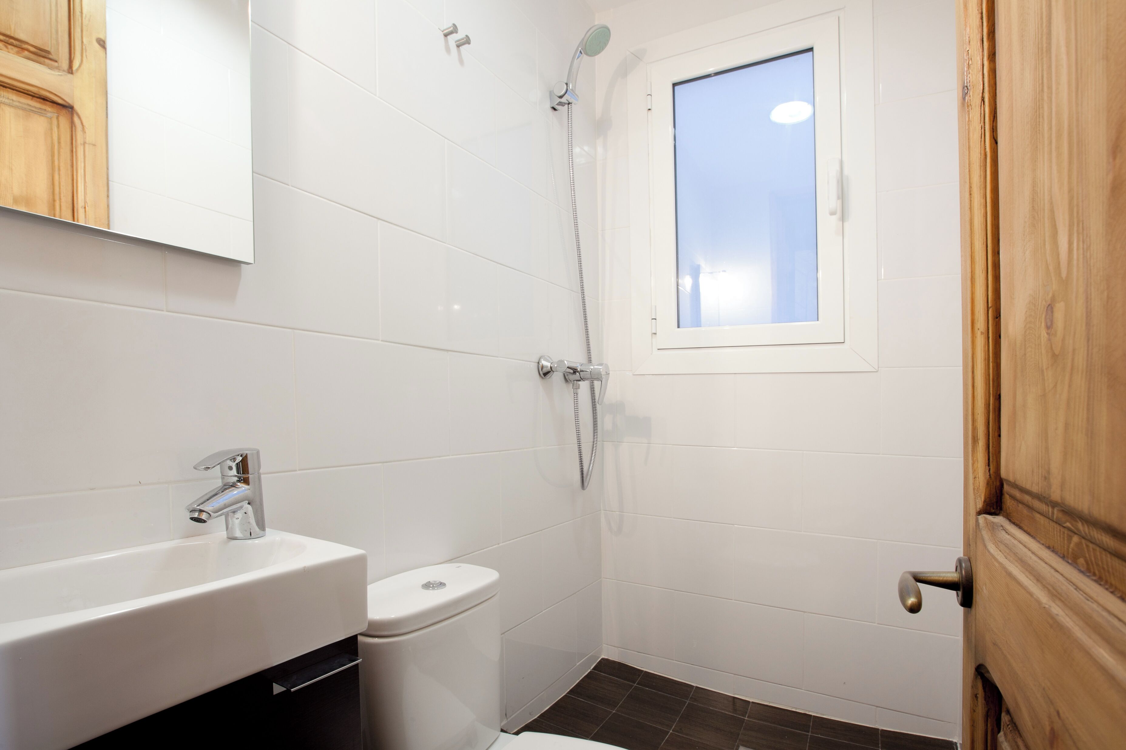 A bathroom with a white sink, toilet, and shower.