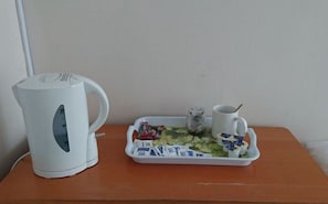 A white electric kettle, a tray with food and condiments, and a mug on a wooden table. - Room-double Room Private Shower Room - d (Hayes)