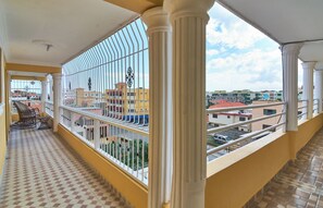 A balcony with a tiled floor, white railings, and a view of buildings in the background. - Spacious 2-bedroom Apartment With 2 Bathrooms Near SDQ Airport Fast Wi-fi & (Santo Domingo Este)