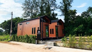 A modern wooden cabin with a sloped roof, large windows, and a small porch. - 2 Tiny Houses on Koh Lanta Only 2 Minutes Walk to the Beach (Ko Lanta)