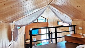 A cozy attic room with wooden walls and a sloped ceiling. - 2 Tiny Houses on Koh Lanta Only 2 Minutes Walk to the Beach (Ko Lanta)